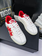 Pair of white low-top sneakers with red star accents and red heel collars