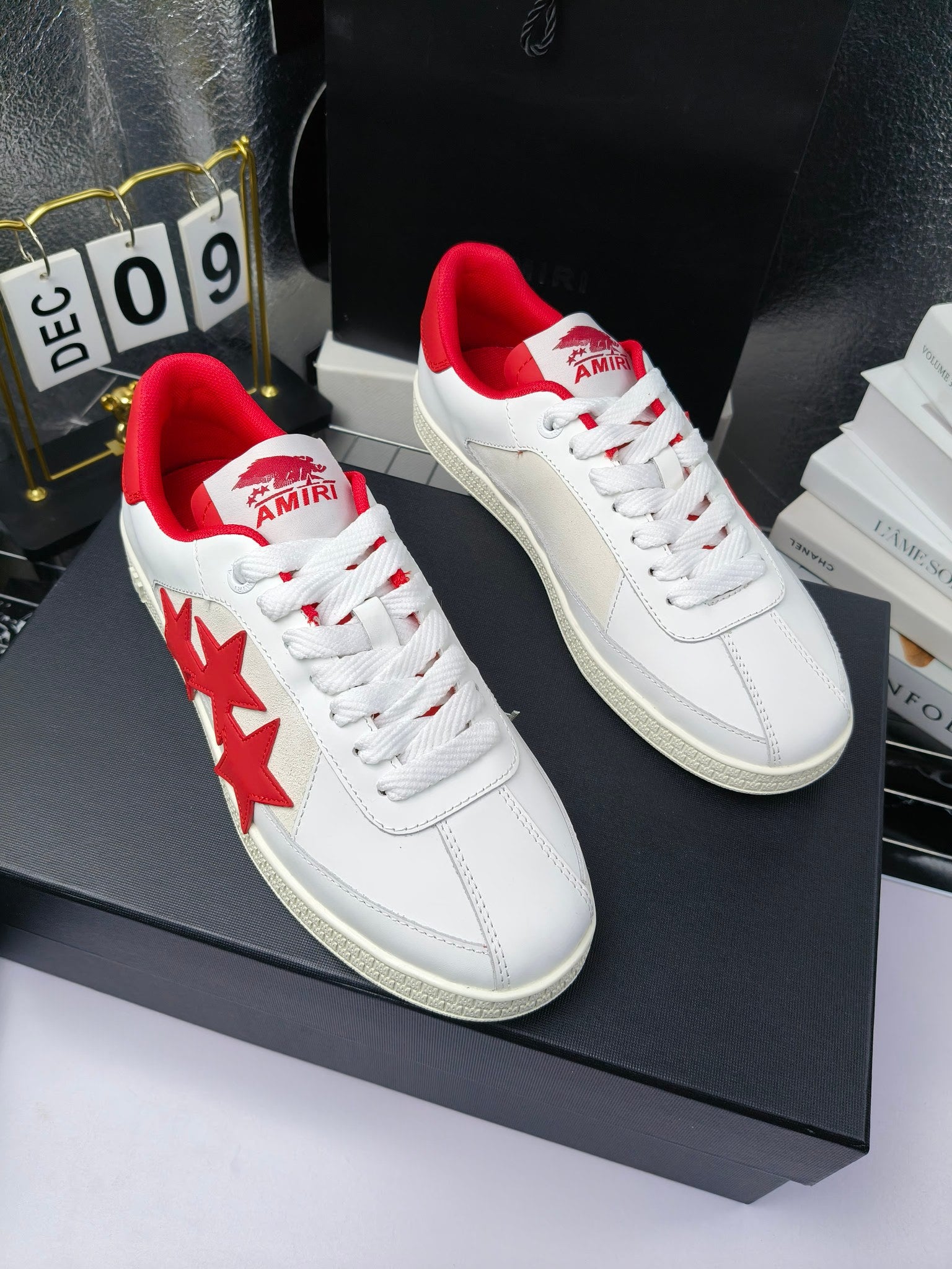 Pair of white low-top sneakers with red star accents and red heel collars