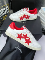 Pair of white low-top sneakers with red star design on the side and red heel trim