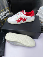 White low-top sneakers with red star patch, red heel lining and textured rubber sole