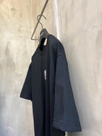 Dark short-sleeve T-shirt on hanger, side view