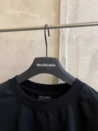 Crew-neck collar of black short-sleeve T-shirt on hanger