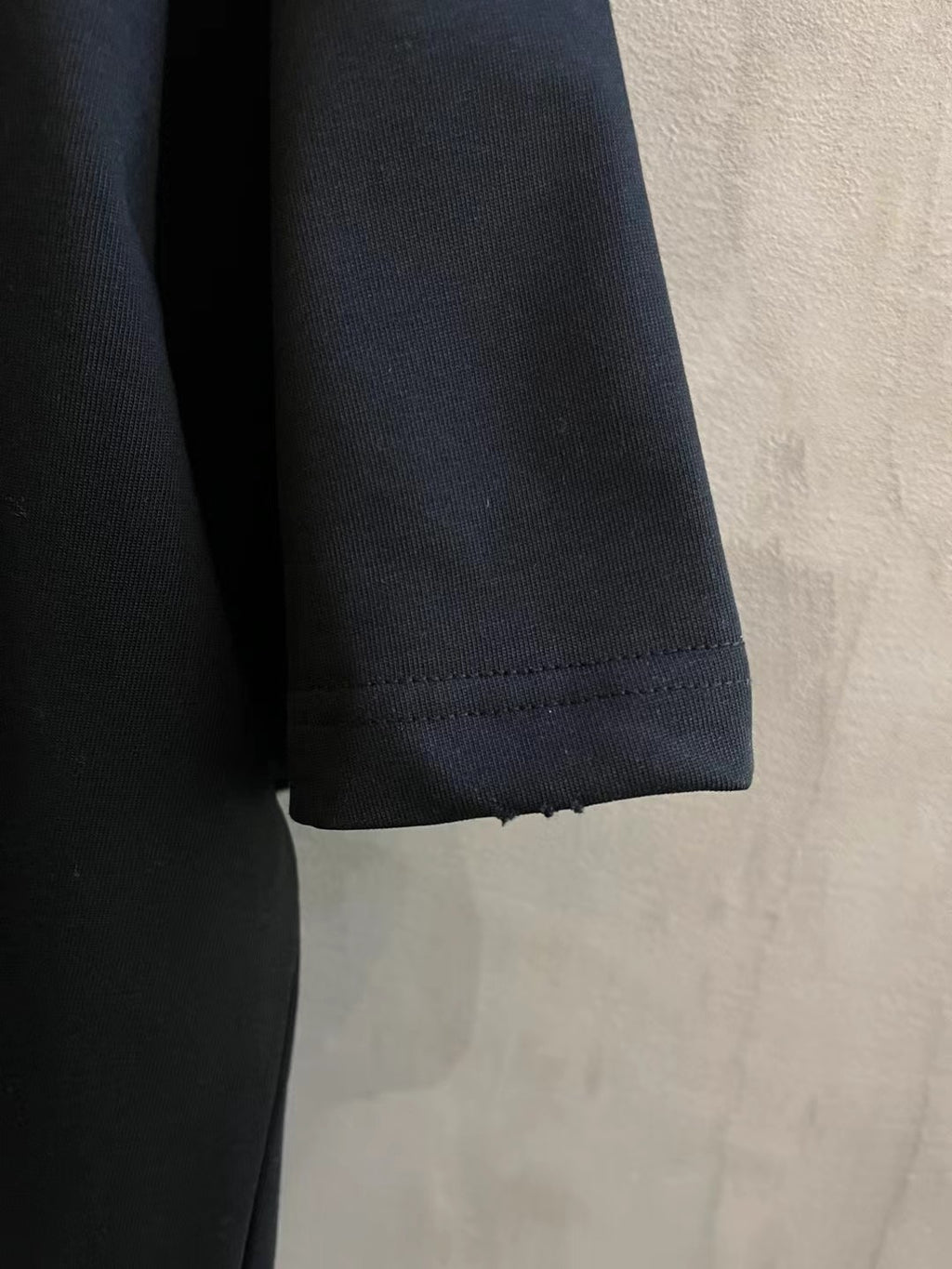 Sleeve and hem edge of dark short-sleeve T-shirt