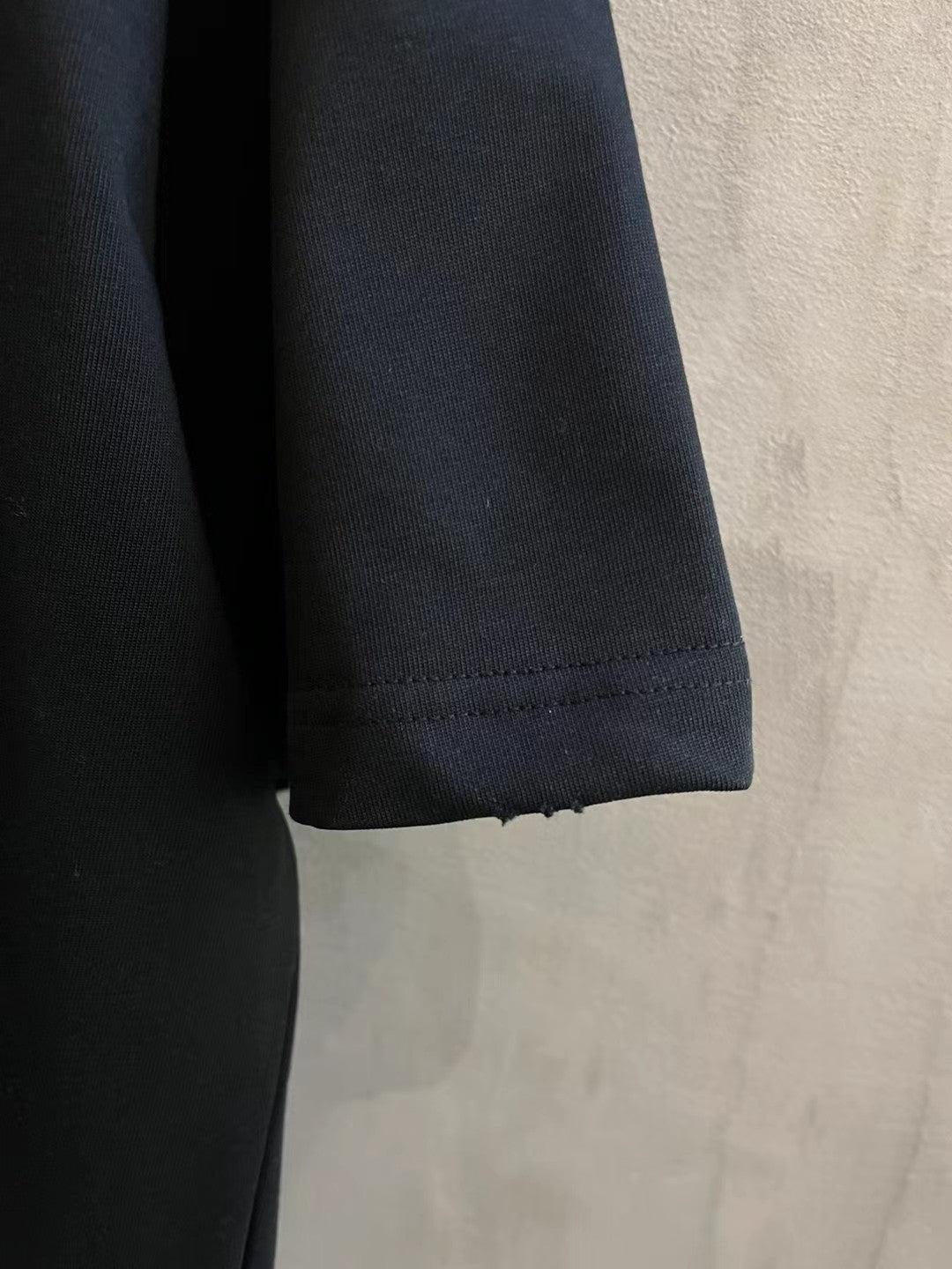 Sleeve and hem edge of dark short-sleeve T-shirt