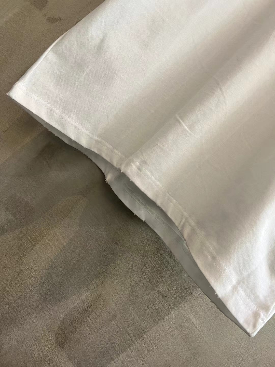 Balenciaga white T-shirt sleeve and curved hem, folded cuff detail