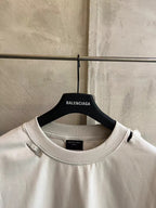 White crew-neck T-shirt close-up with black brand tag inside neckline