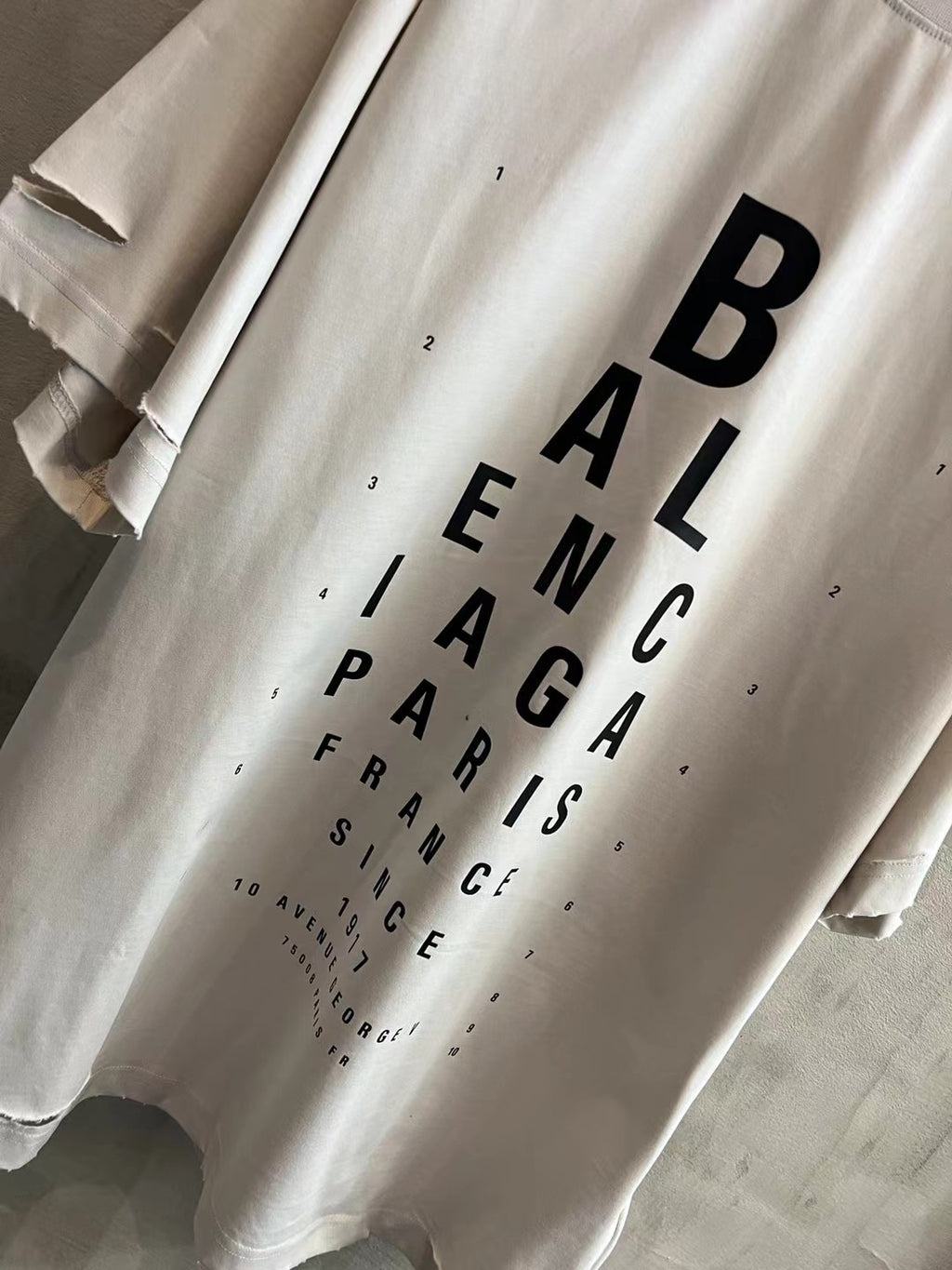 White short-sleeve T-shirt with large black vertical BALENCIAGA wordmark graphic