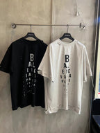 Black and white short-sleeve T-shirts on hangers with vertical BALENCIAGA logos
