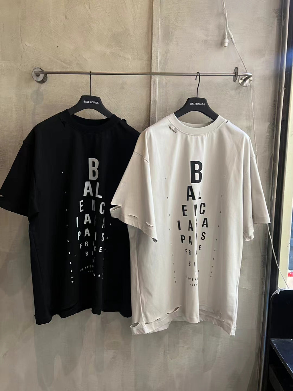Balenciaga logo T-shirts, black and white, hanging side by side
