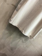 White T-shirt sleeve and hem close-up with frayed, distressed edges