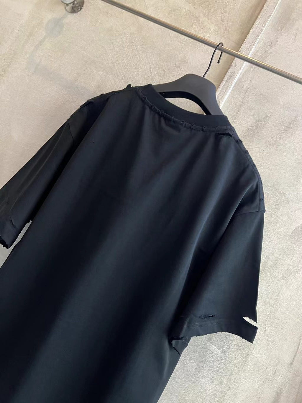 Balenciaga black T-shirt with crew neck and short sleeves, rear view on hanger