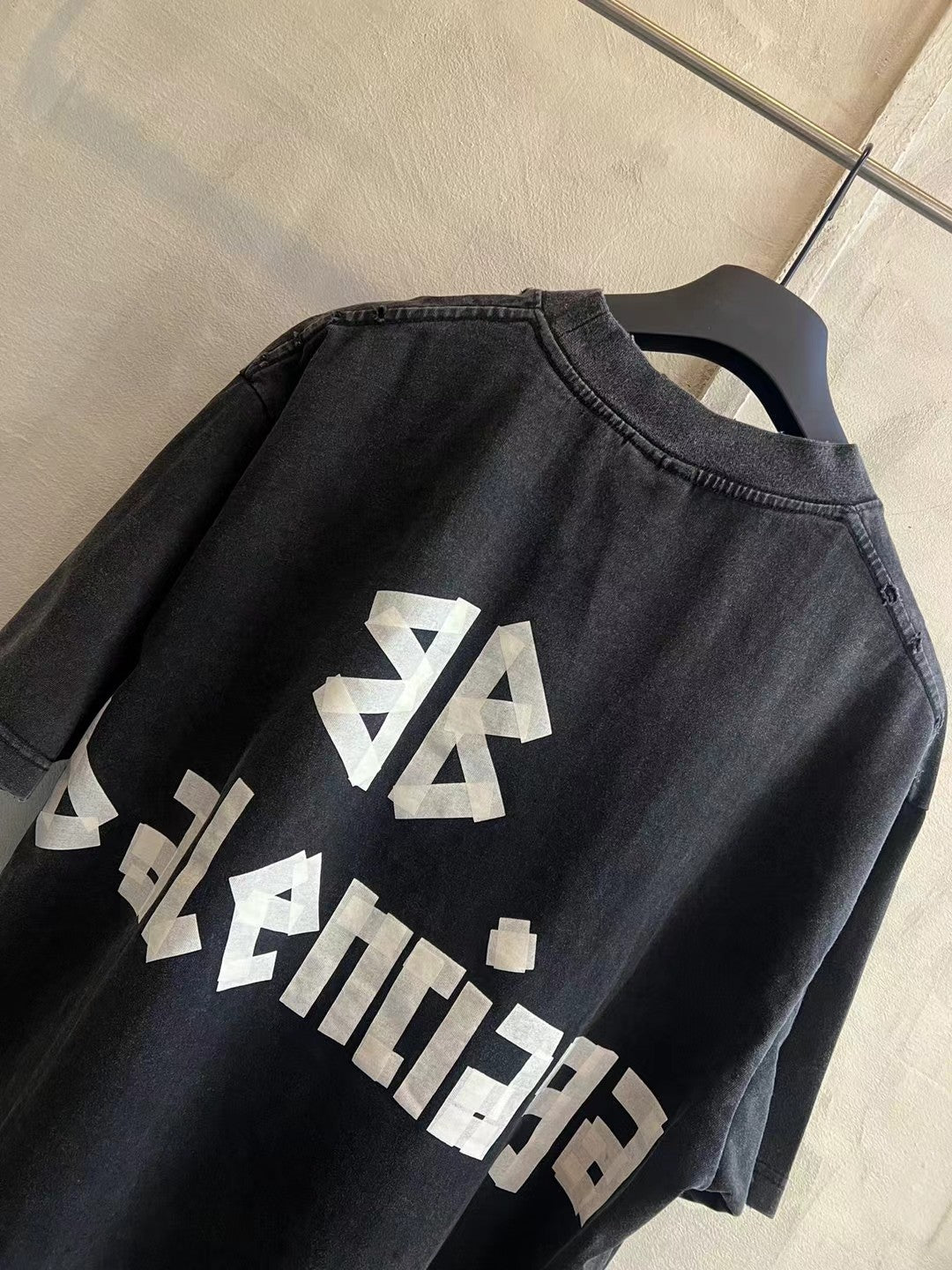 Black T-shirt back detail with white diagonal BALENCIAGA logo graphic