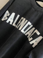 Black T-shirt sleeve detail with white BALENCIAGA logo graphic