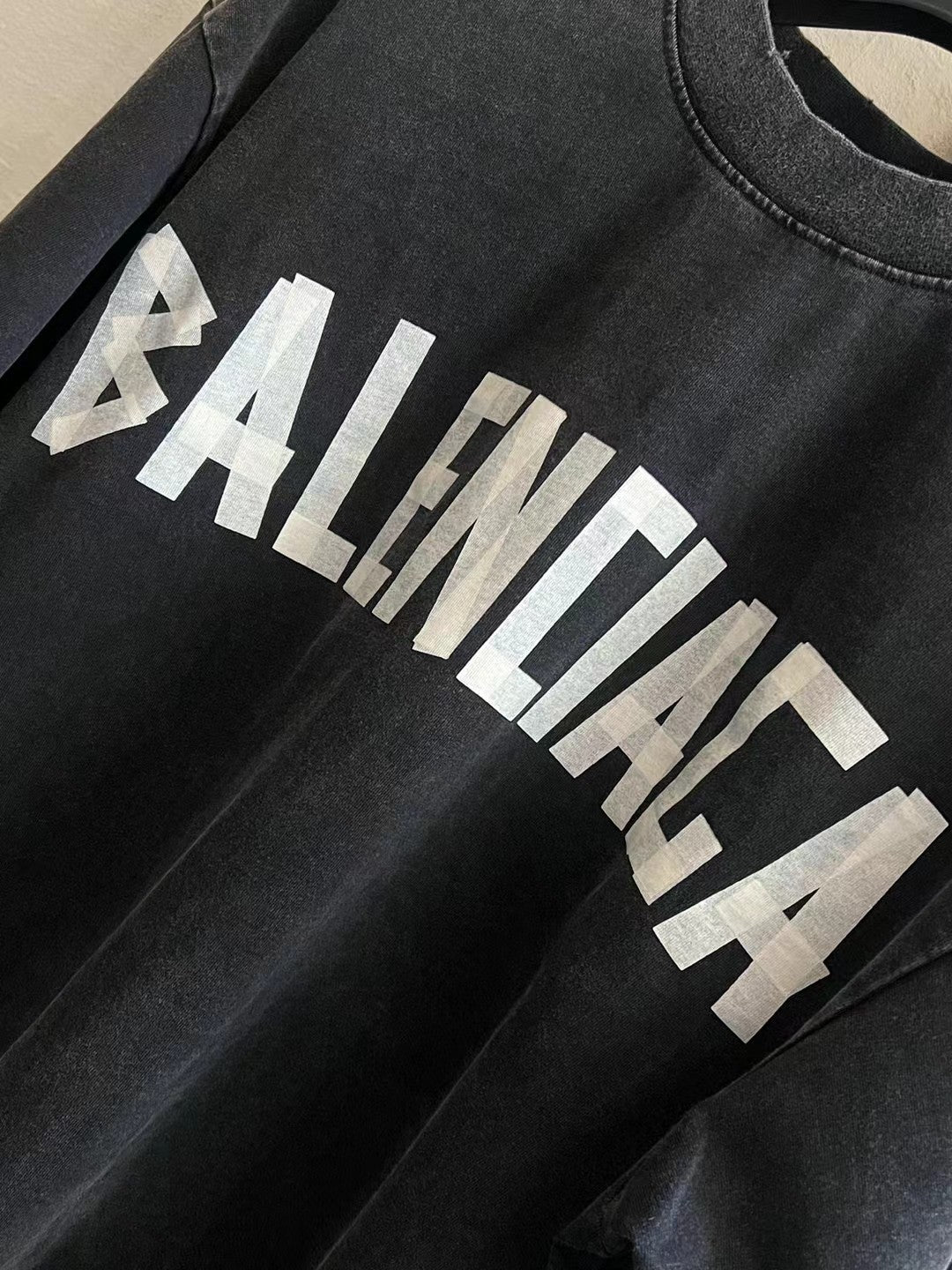 Black T-shirt sleeve detail with white BALENCIAGA logo graphic