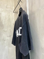 Black T-shirt side view with partial white logo print and short sleeves