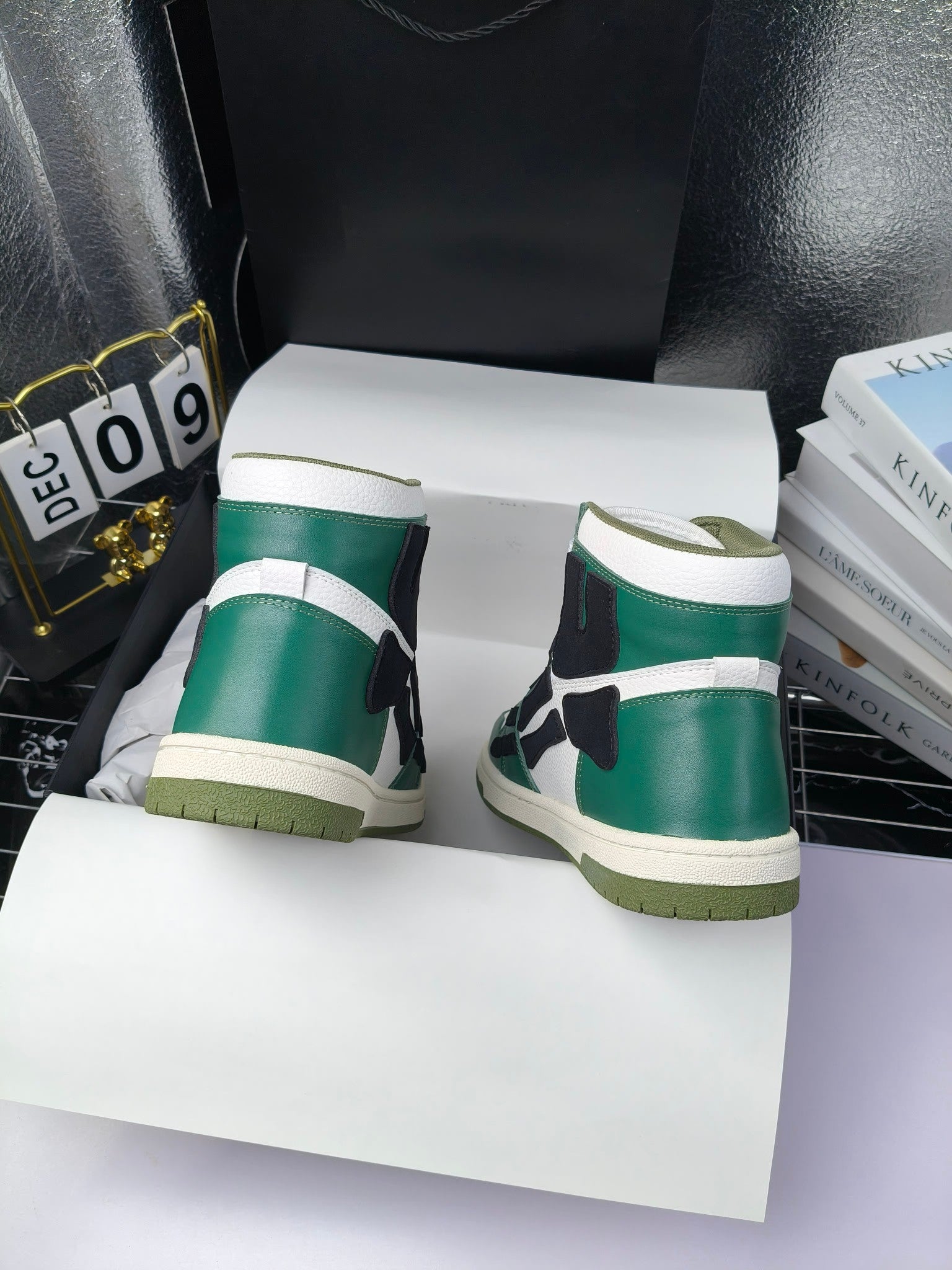 Green and white high-top sneakers with black side panels and cream outsole, heel view.