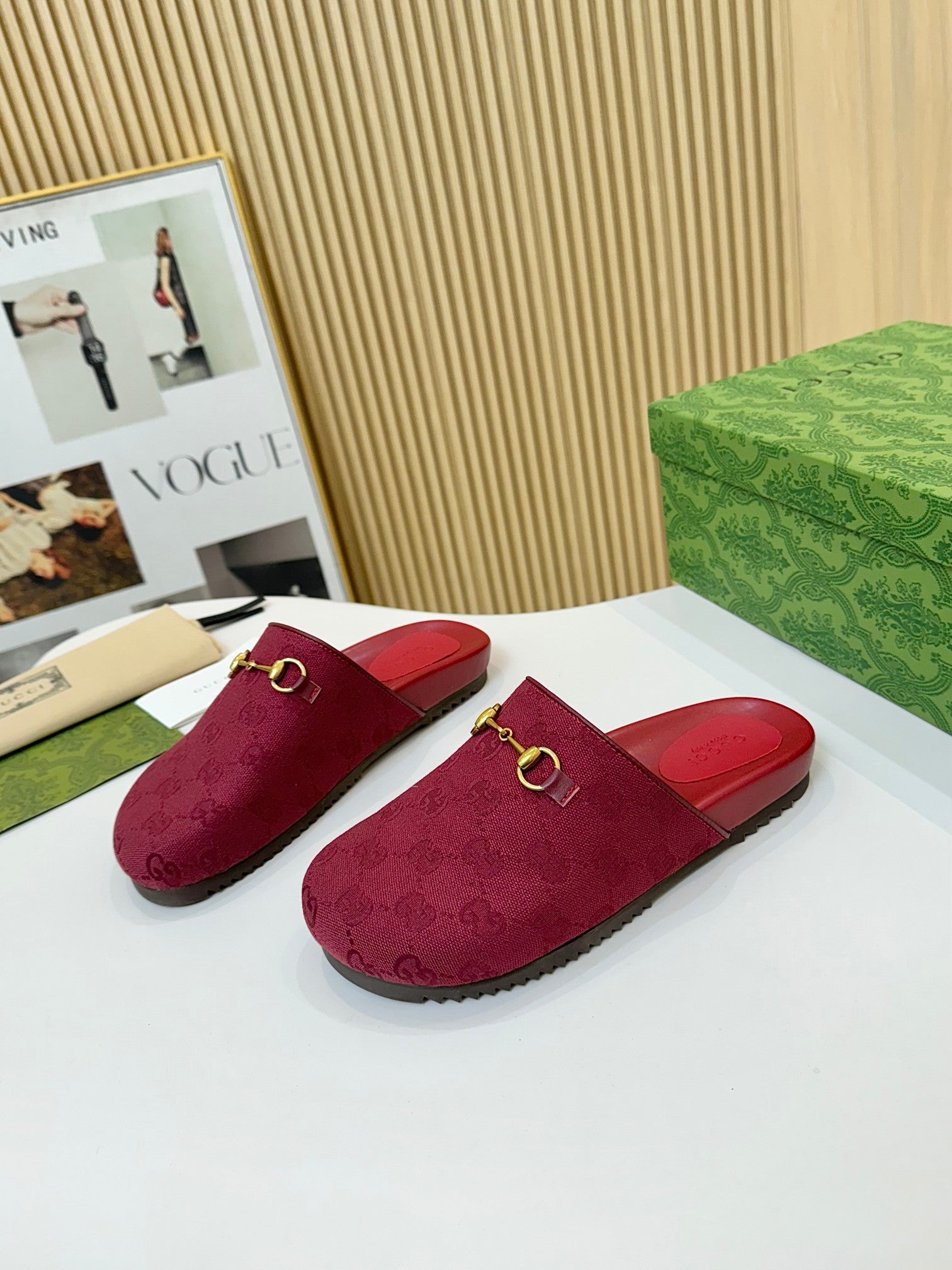 Gucci mule sandals, dark red GG-patterned fabric with gold buckle detail on the vamp