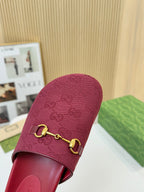 Gucci dark red mule sandal close-up with GG monogram fabric and gold buckle hardware