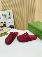 Gucci mule sandals with dark red textured uppers, GG pattern, and gold-tone buckle strap