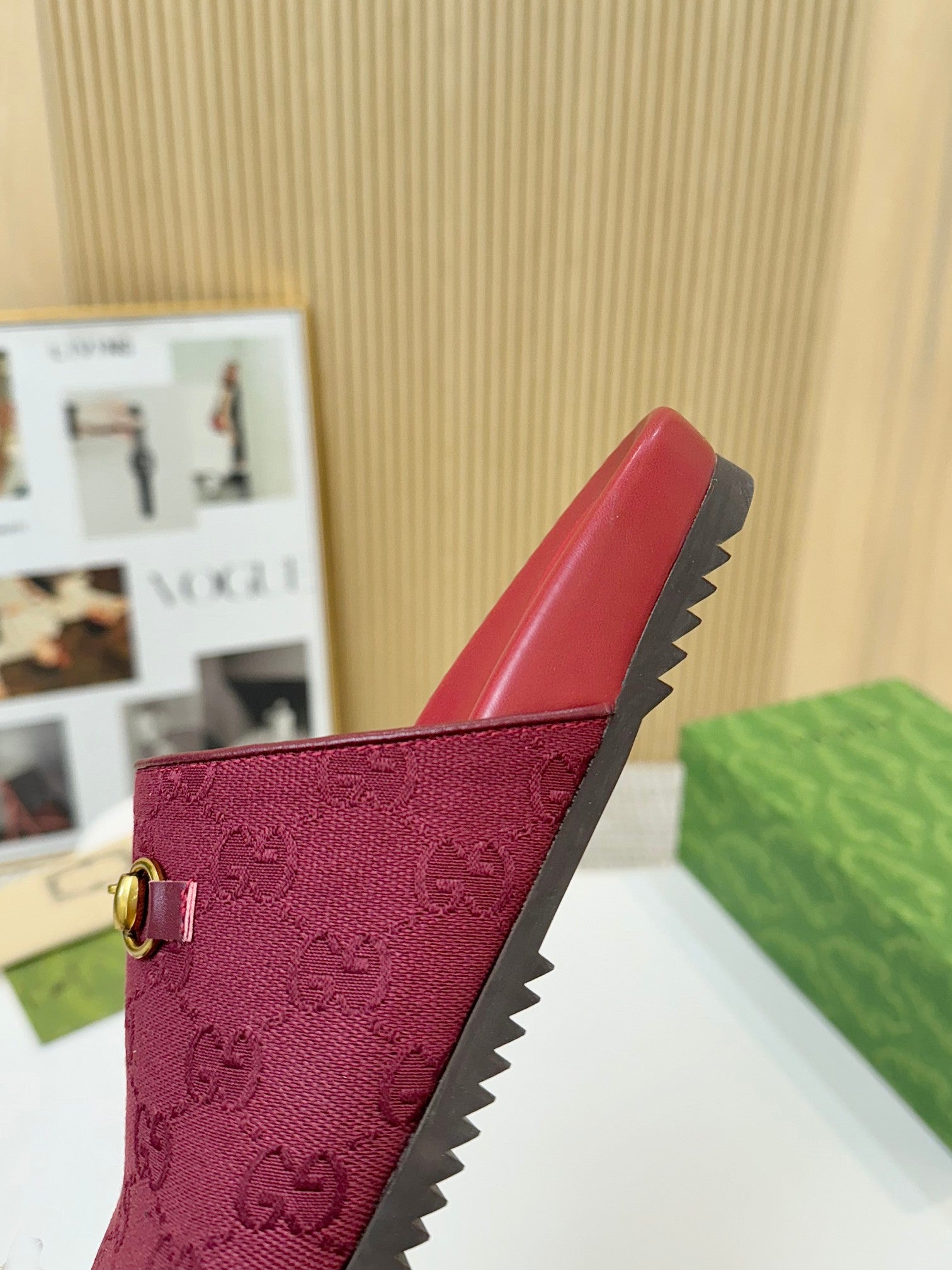 Gucci mule sandal in dark red with GG pattern and gold buckle; visible textured side sole