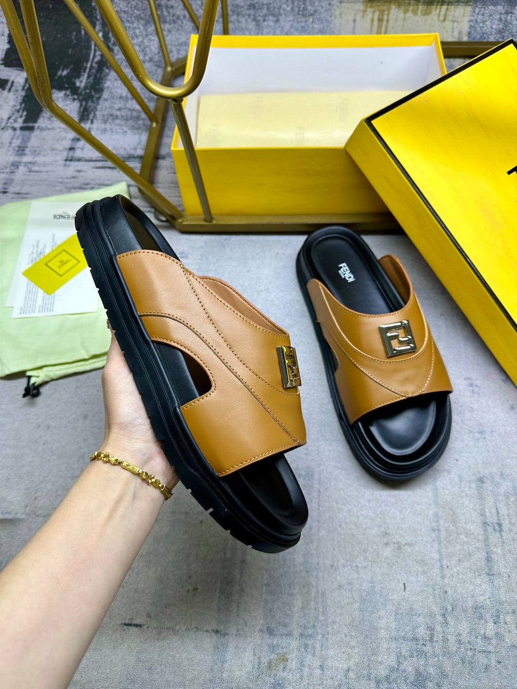 Fendi leather sandals in tan with black soles and gold buckle detail.