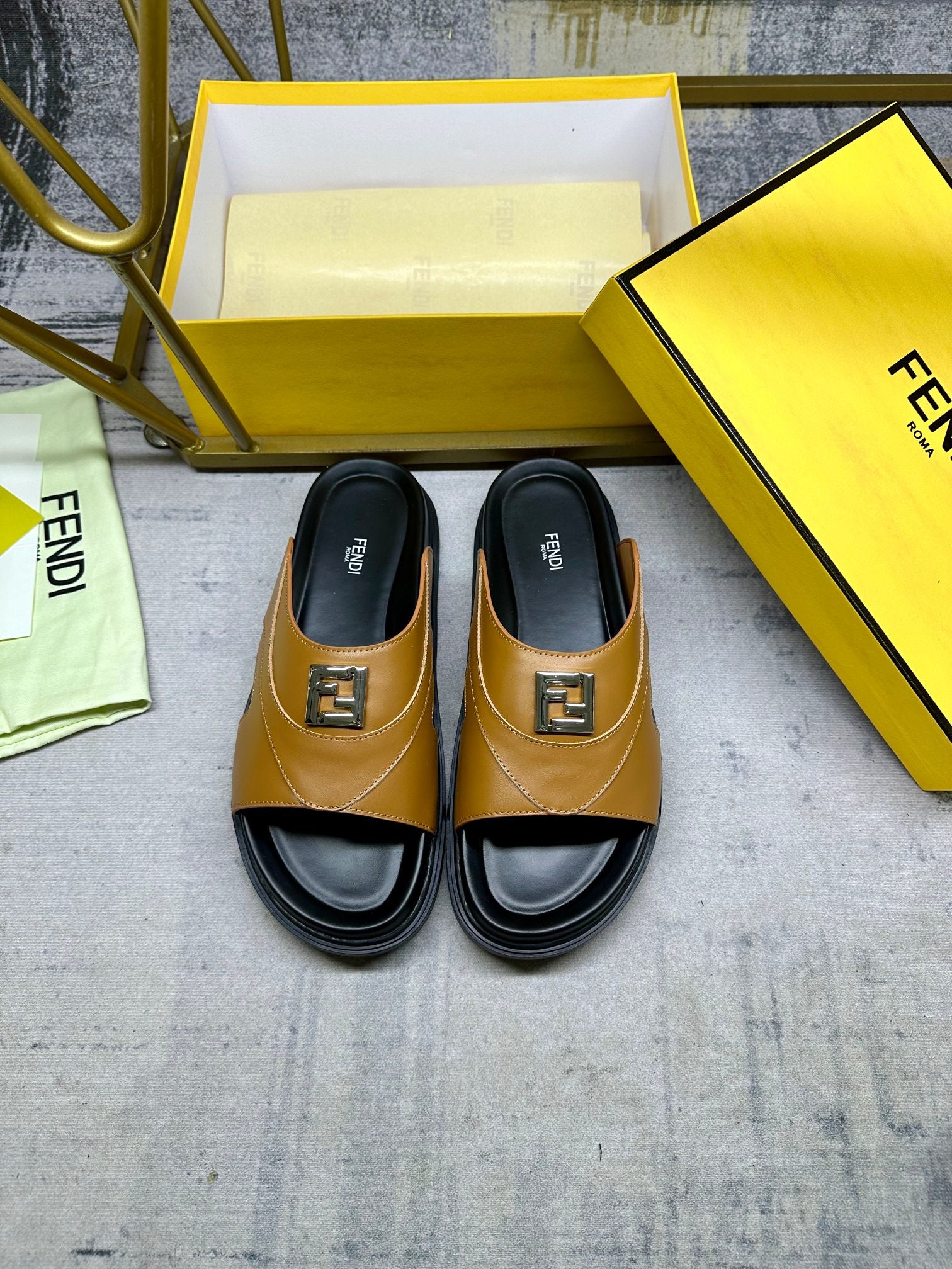 Pair of Fendi slide sandals, tan leather with black footbed and logo buckle.