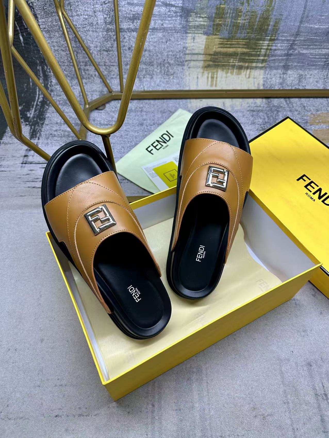 Fendi slide sandals, tan leather uppers and black soles with gold square buckle.