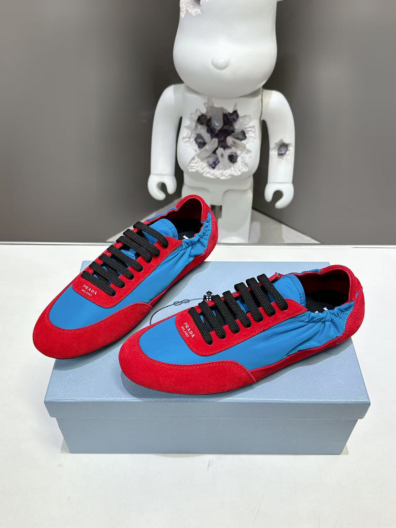 Prada unisex sneakers, red and blue uppers with black lace-up front, on box