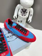 Prada unisex sneakers close-up: black laces on red and blue suede panels