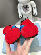 Prada unisex sneakers with red heels and blue uppers, held in hands