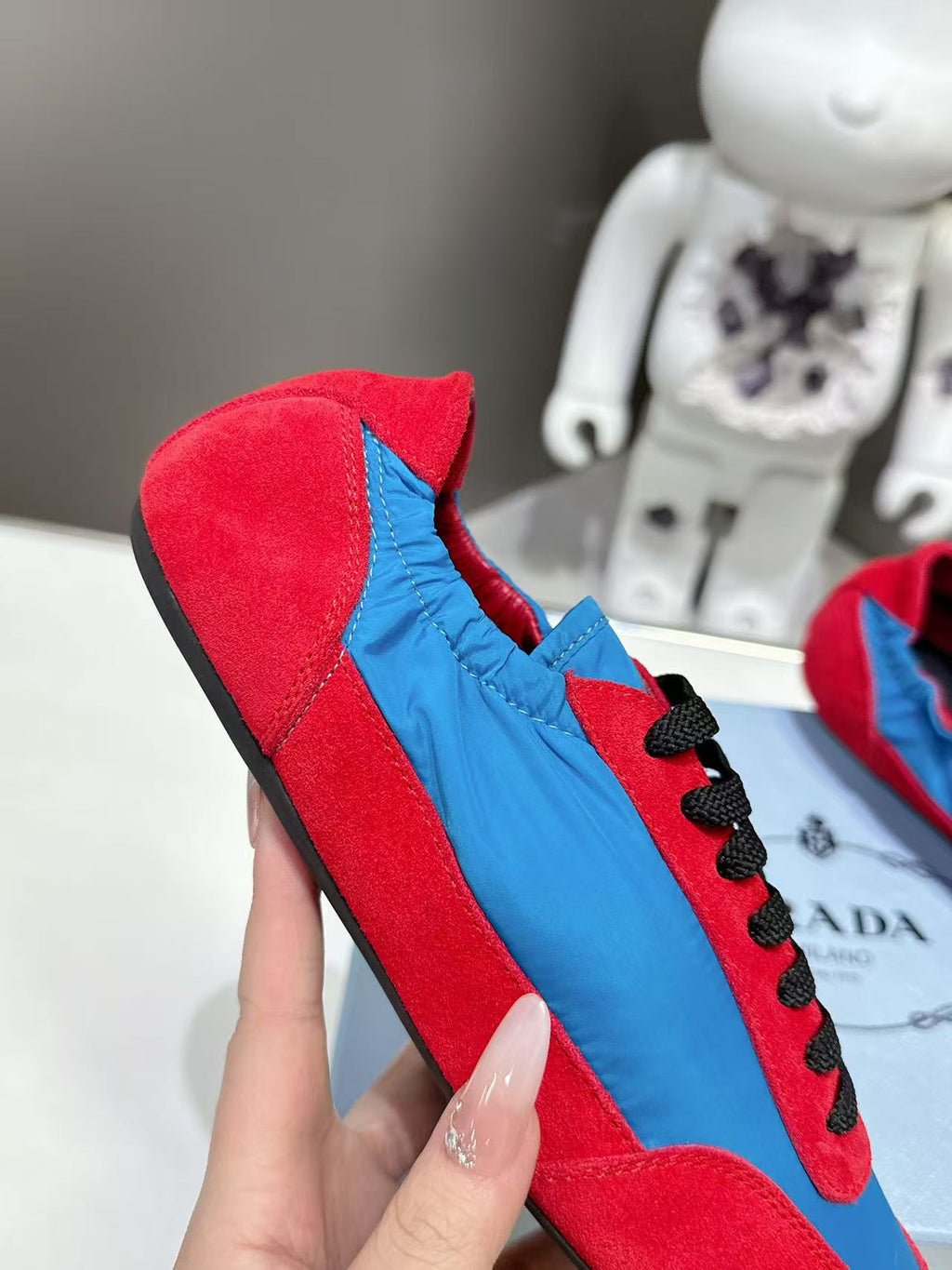 Prada unisex suede sneaker, red upper with blue panel and black laces, side view