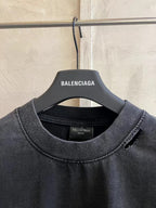 Black crewneck T-shirt close-up with Balenciaga neck label and stitched collar