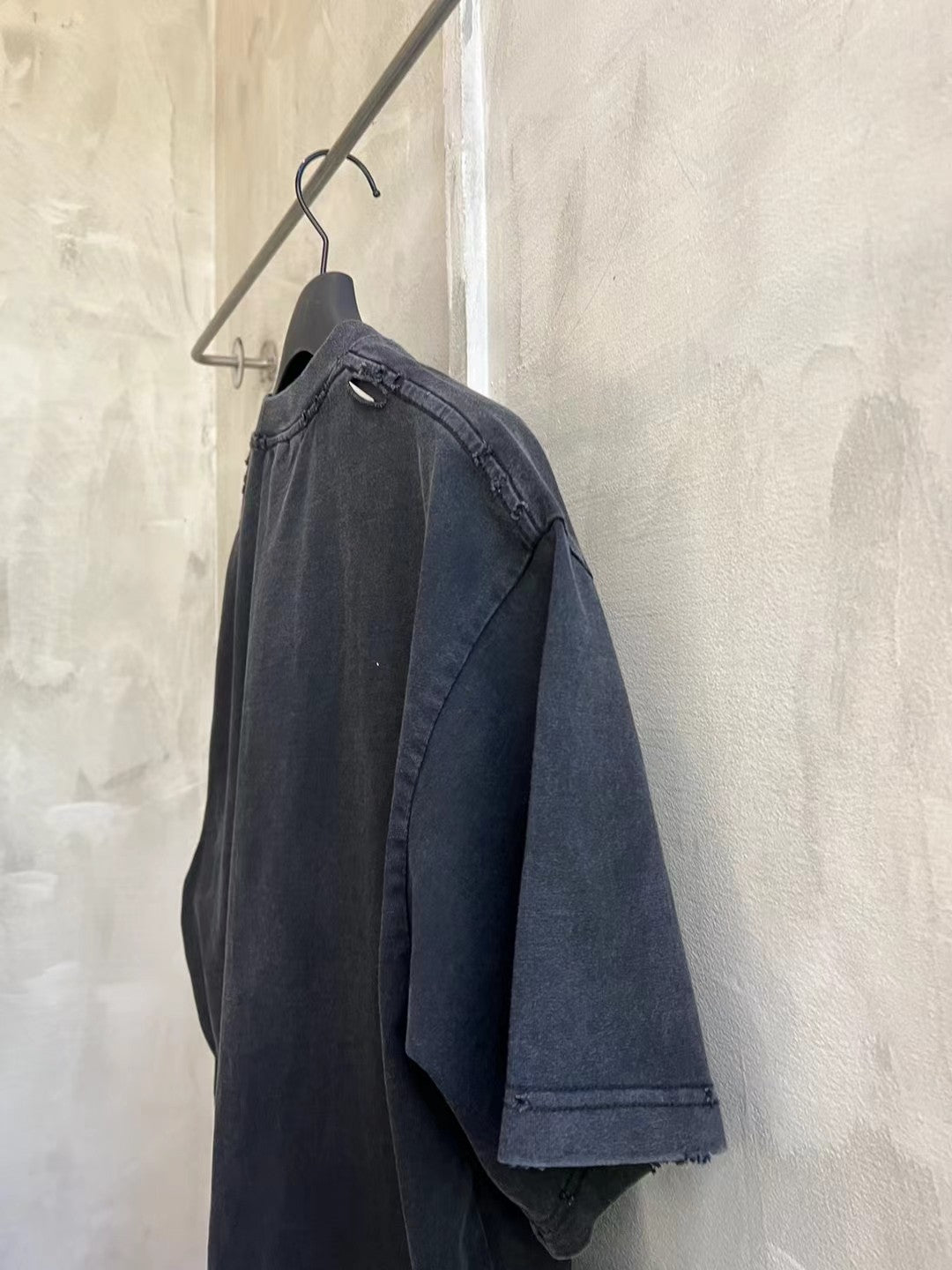 Dark navy/black short-sleeve T-shirt side view on hanger with straight shoulder seam