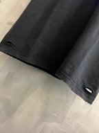 Black T-shirt cuff close-up with small ventilation slit and stitched hem detail