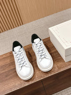 Alexander McQueen white leather sneakers with black tongue lining, lace-up and flat sole.