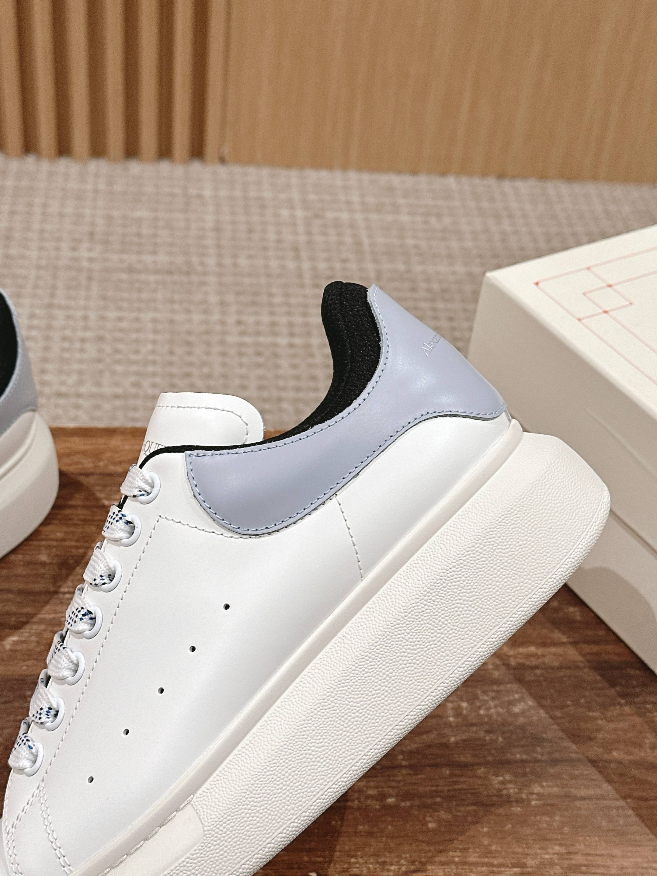 White leather sneakers with light blue side panels and black collar