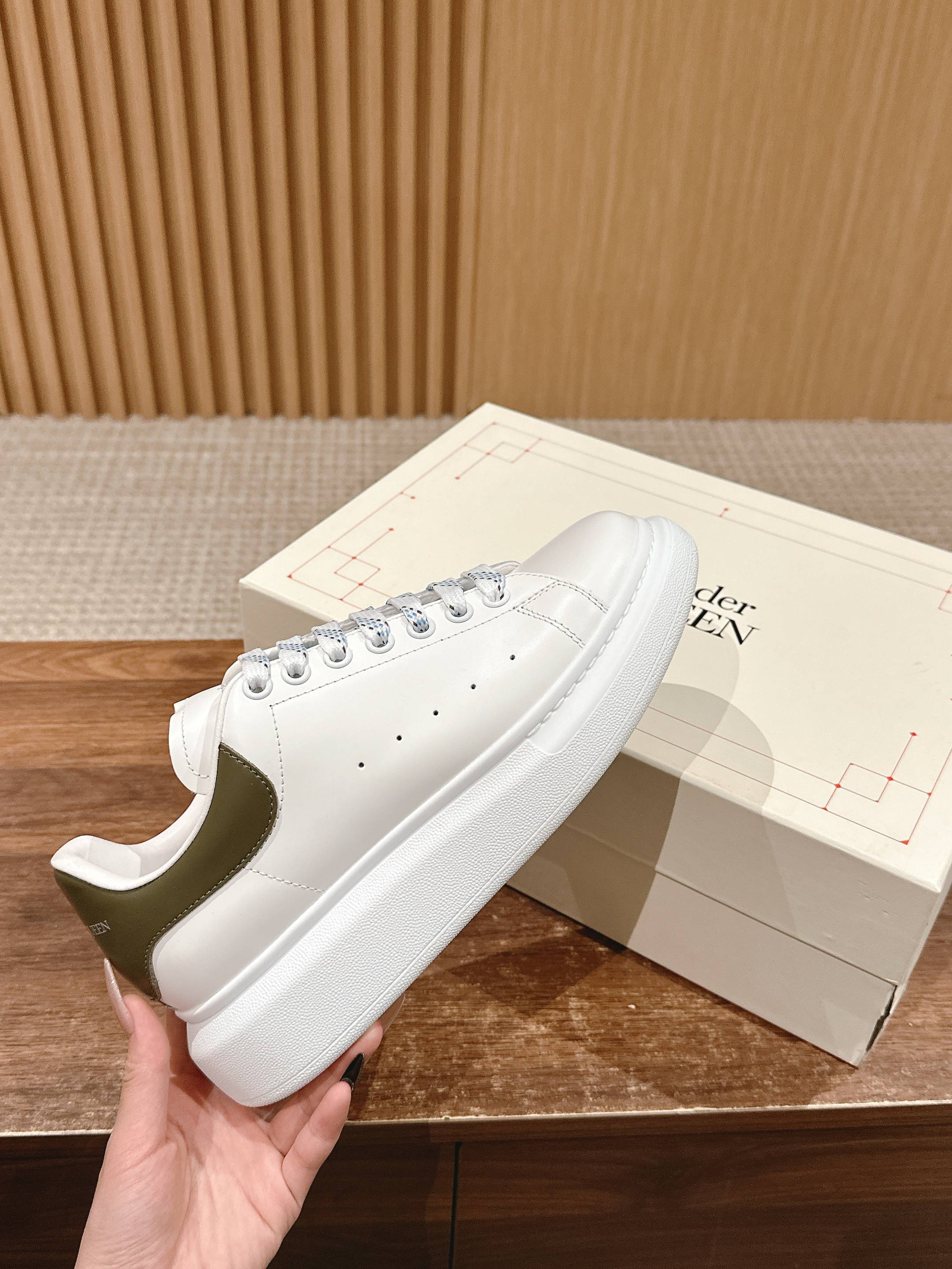 White leather low-top sneakers with lace-up front and perforated toe