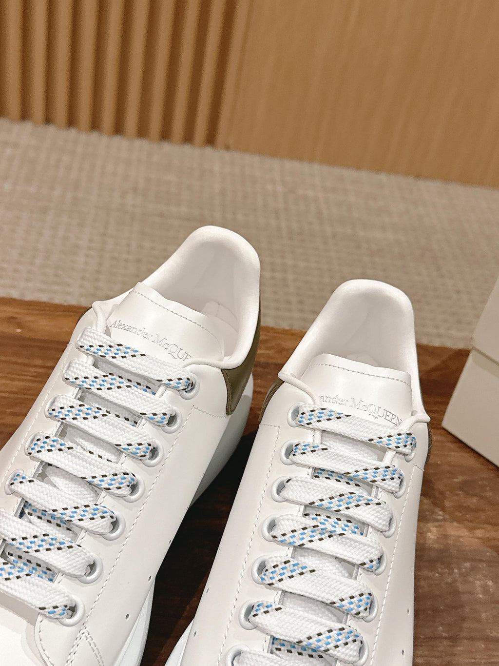 Close view of white low-top sneakers with blue-thread laces