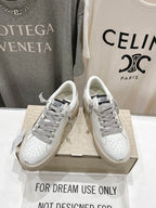 Golden Goose white sneakers with gray laces, side view, on shoebox