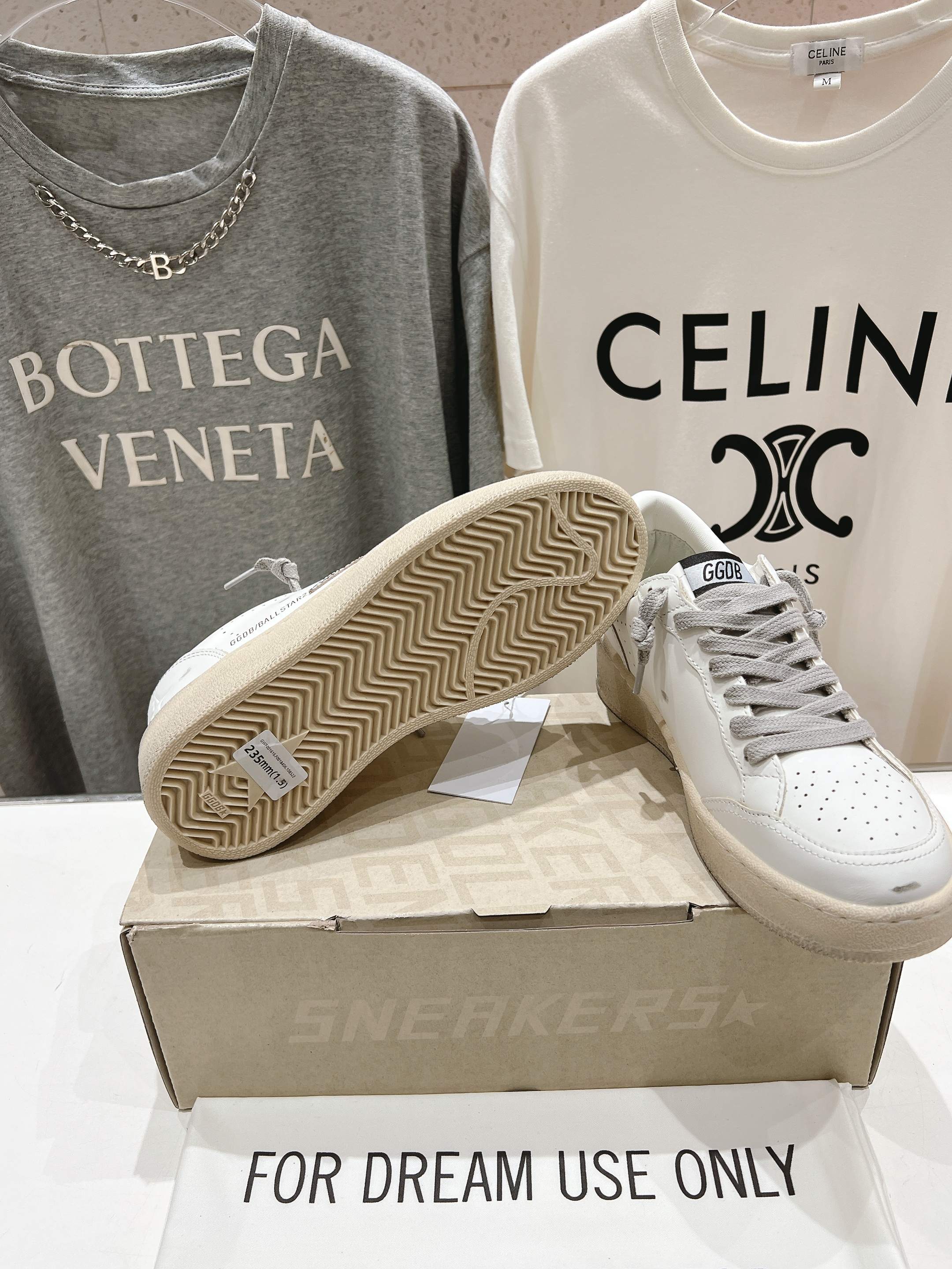 Golden Goose white sneakers with gray laces, open sole showing herringbone tread