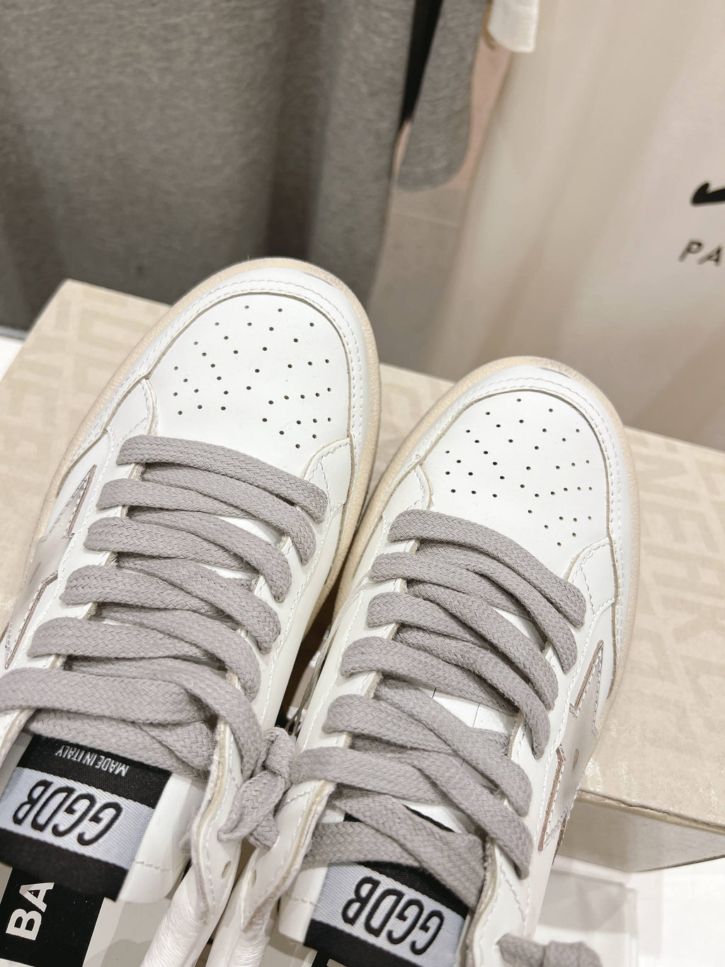 Golden Goose white sneakers with gray laces, close-up of front toe area