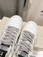 Golden Goose white sneakers with gray laces, close-up of front toe area