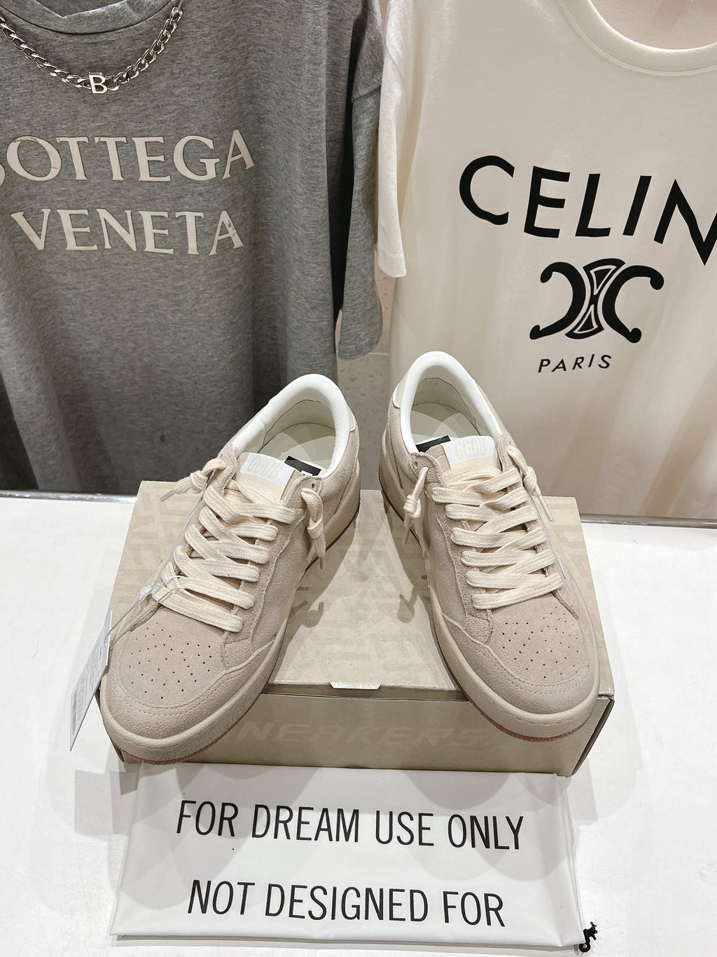 White low-top lace-up sneakers with perforated toe, pair on shoebox
