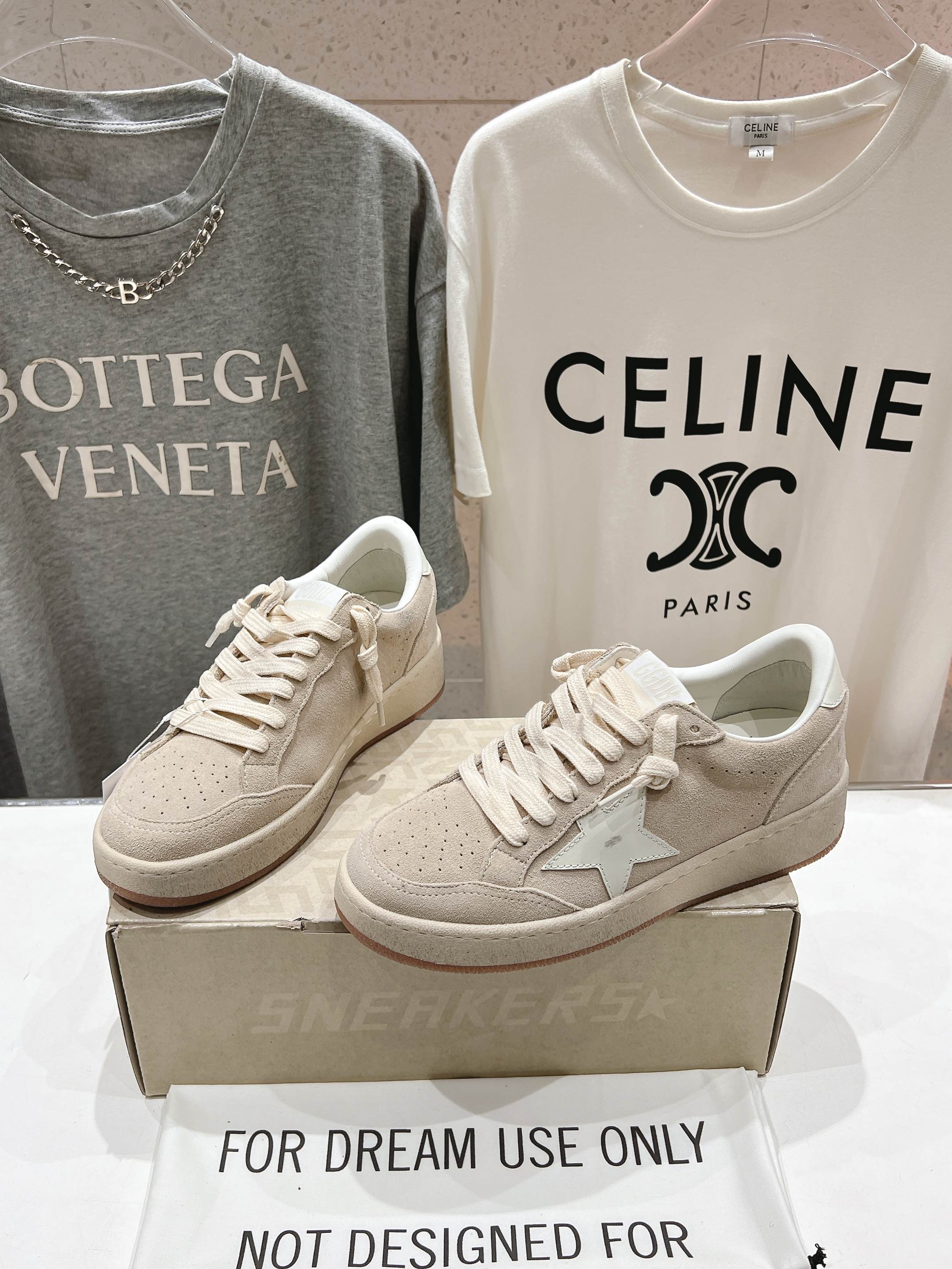 White low-top sneakers with lace-up and side star detail, pair on shoebox