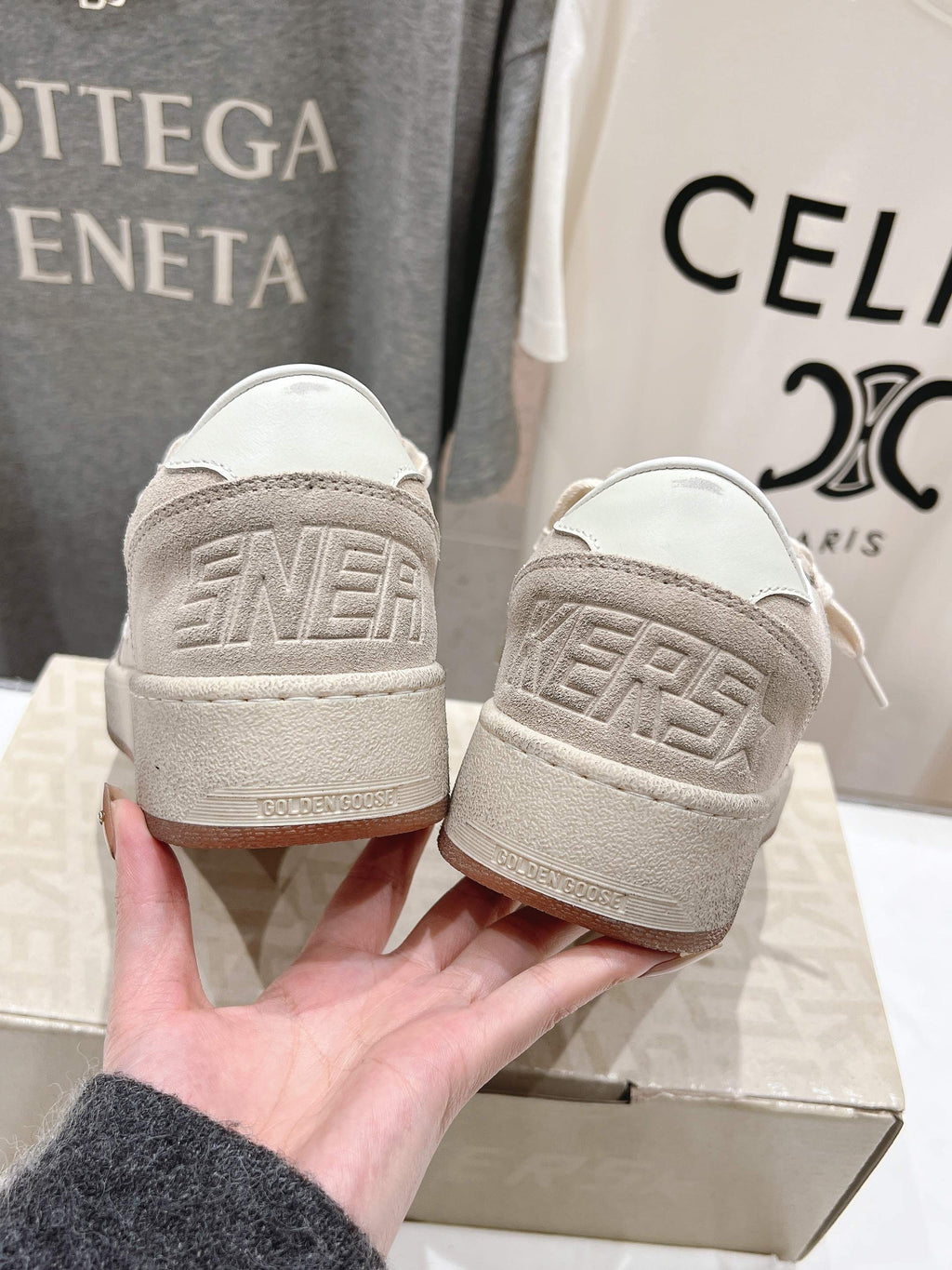 White sneakers back view with embossed heel detail, pair on shoebox