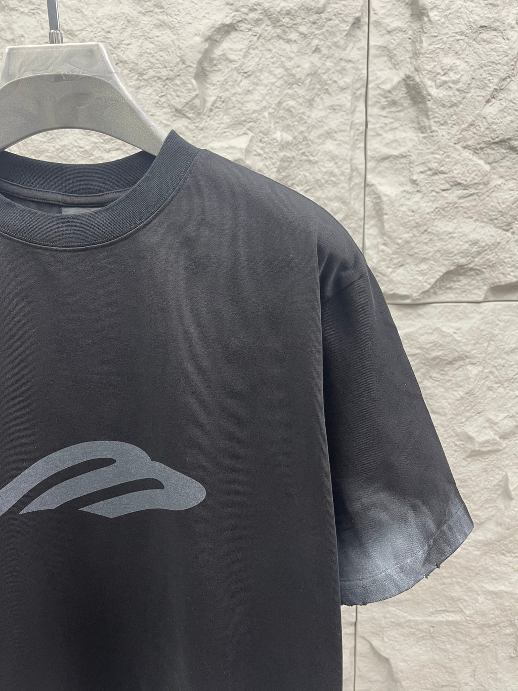 Dark graphic T-shirt detail with chest logo print