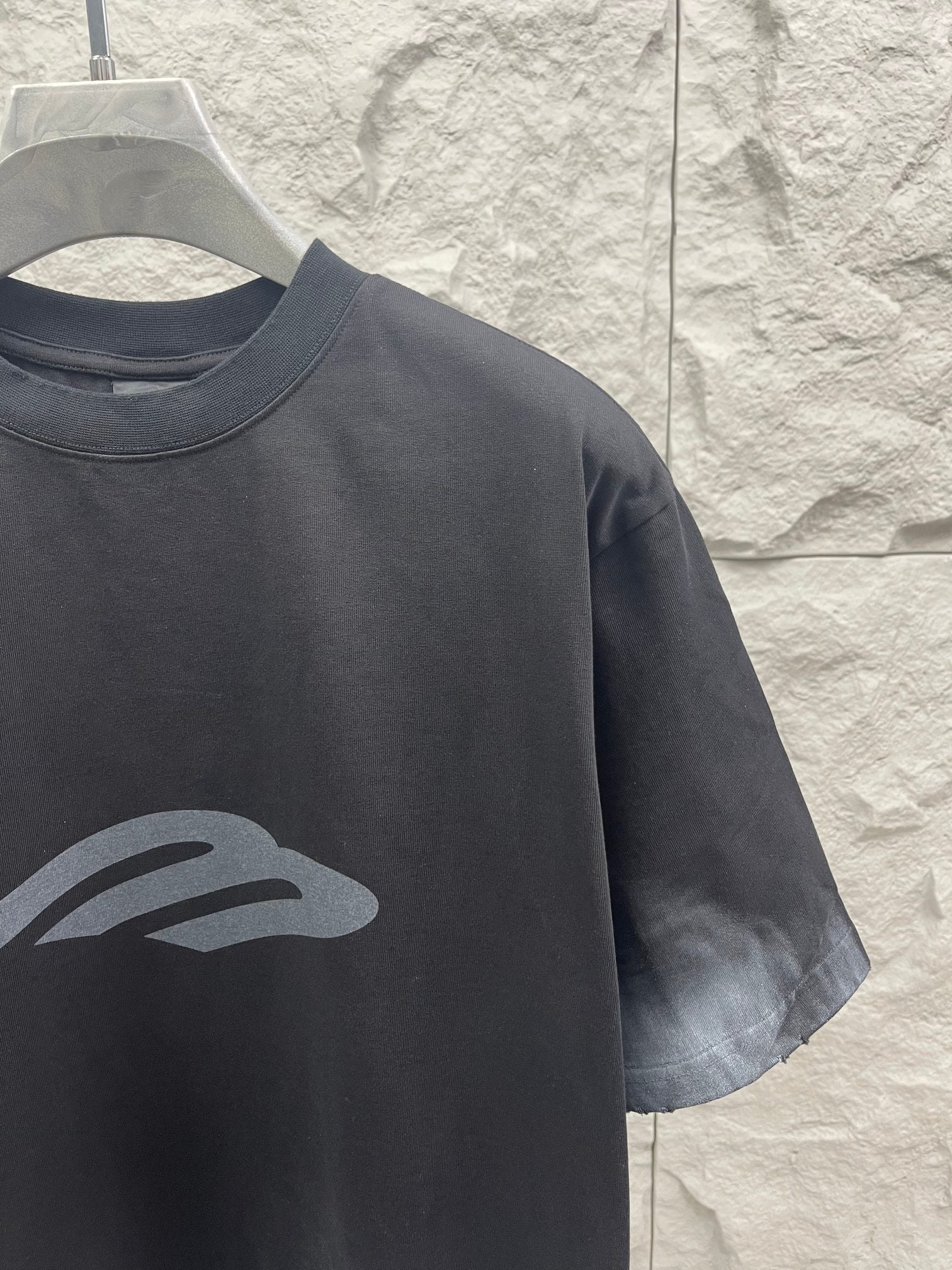 Dark graphic T-shirt detail with chest logo print