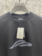 Dark graphic T-shirt close-up with hang tag and chest logo