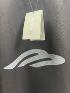 Dark T-shirt fabric close-up with hang tags and logo print