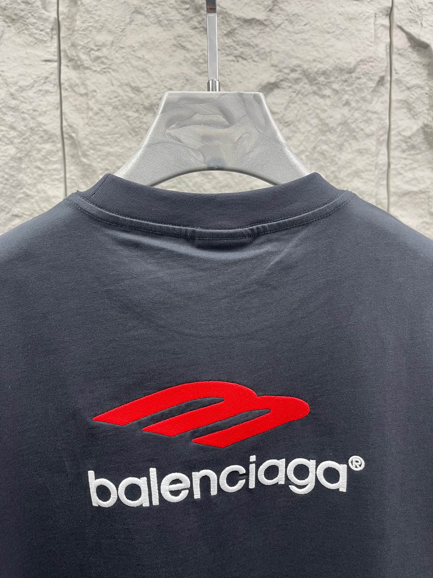 Balenciaga dark T-shirt with red logo graphic and crew neck, front close-up